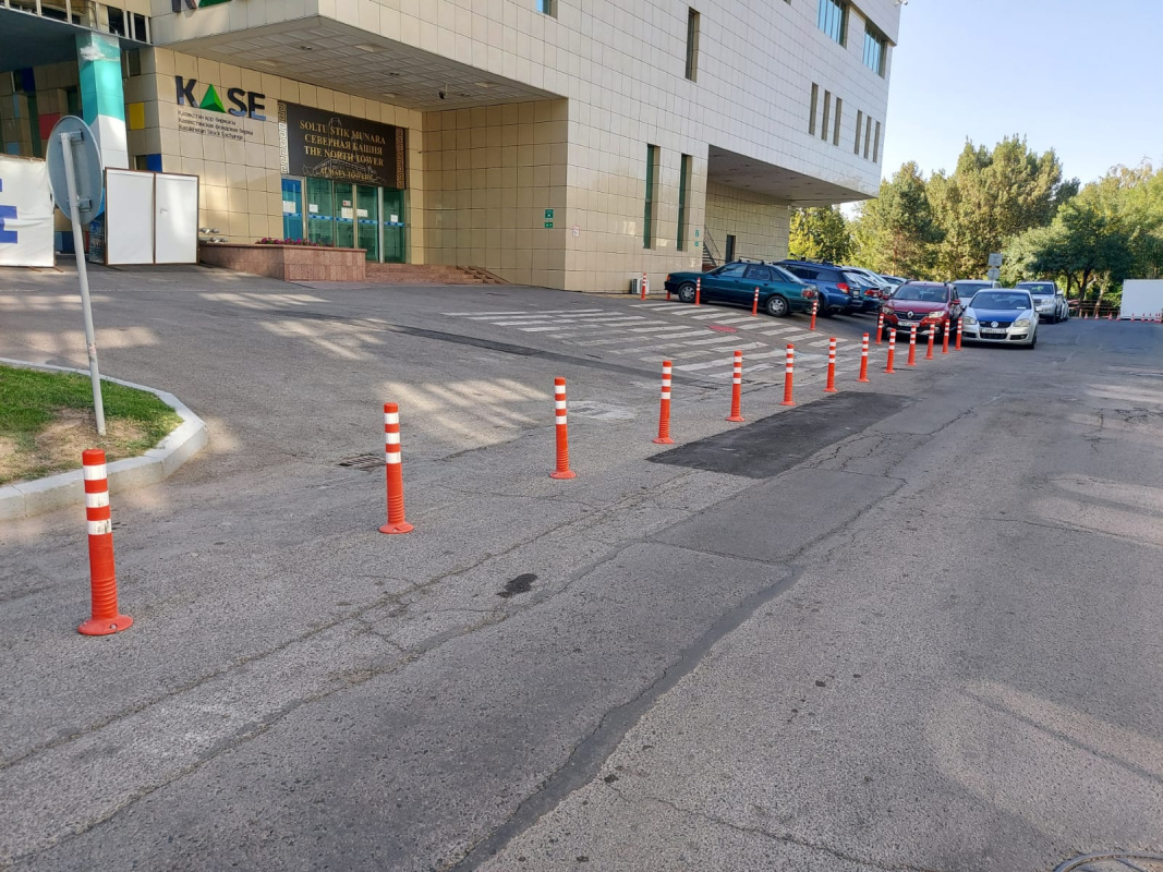 Открытый паркинг у МФК Almaty towers, оснащенный гибкими столбиками для парковки