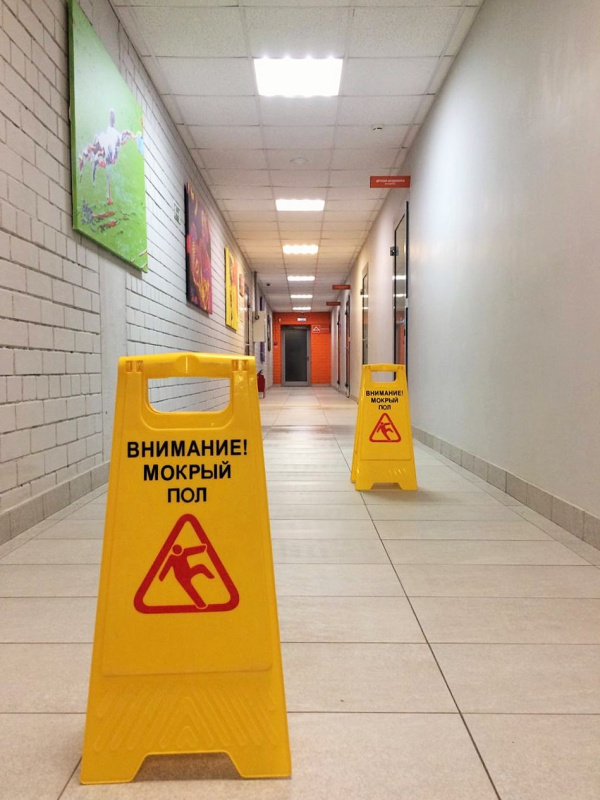 Предупреждение падения людей на скольком полу с помощью знака «Внимание! Мокрый пол»