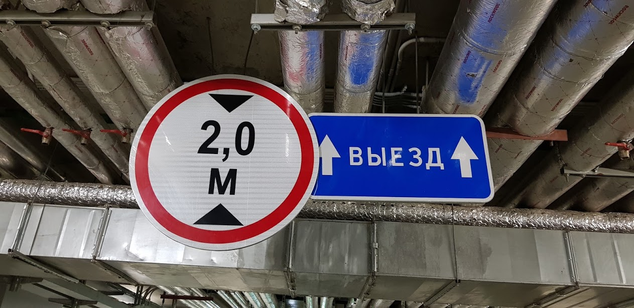 Табличка, указывающая направление выезда и дорожные знак ограничения высоты ТС