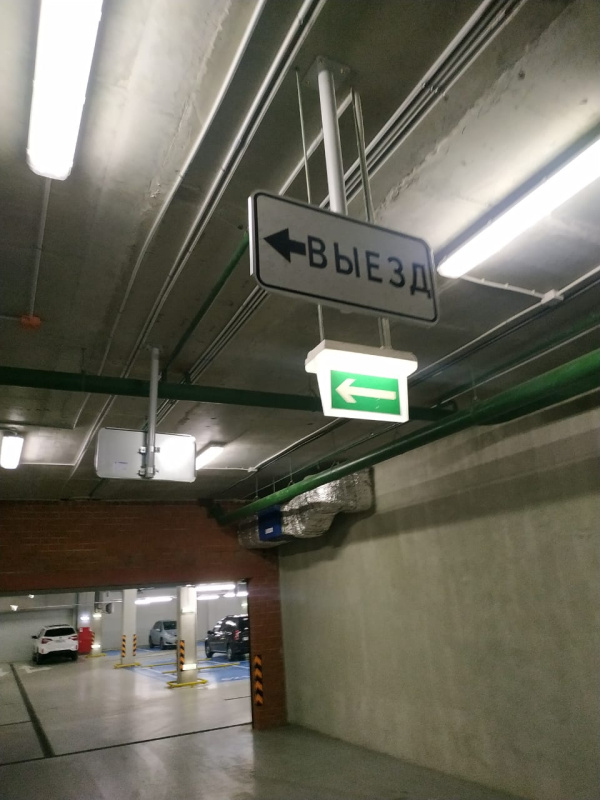 Знак и световая табличка, указывающие направление выезда с подземной парковки, ул. Паршина, д.10, г. Москва