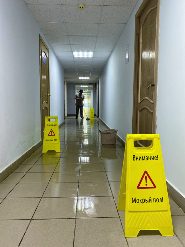 Предупреждение поскальзывания людей при проведении влажной уборки с помощью таблички «Мокрый пол»